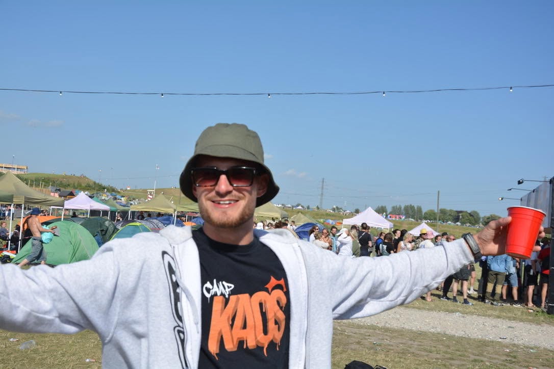 Festivalgæst i Camp Kaos-trøje med armene ud